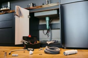 Open door of cabinet under sink in the kitchen